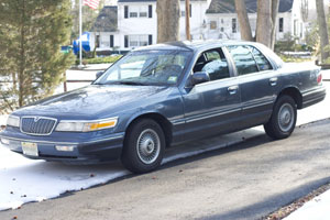 A purple Mercury Grand Marquis on our lawn